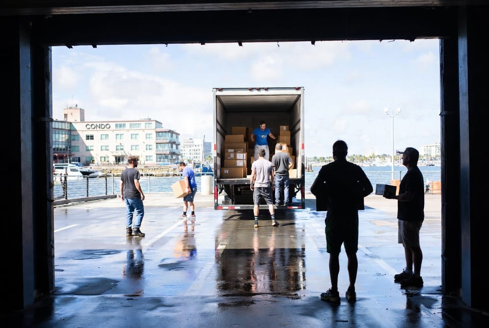 Moving truck parked near the Halifax waterfront with the harbor bridge in view